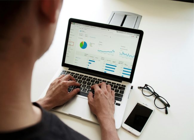 Persona trabajando con un portátil y herramientas de IA, representando la política de uso de inteligencia artificial en la empresa